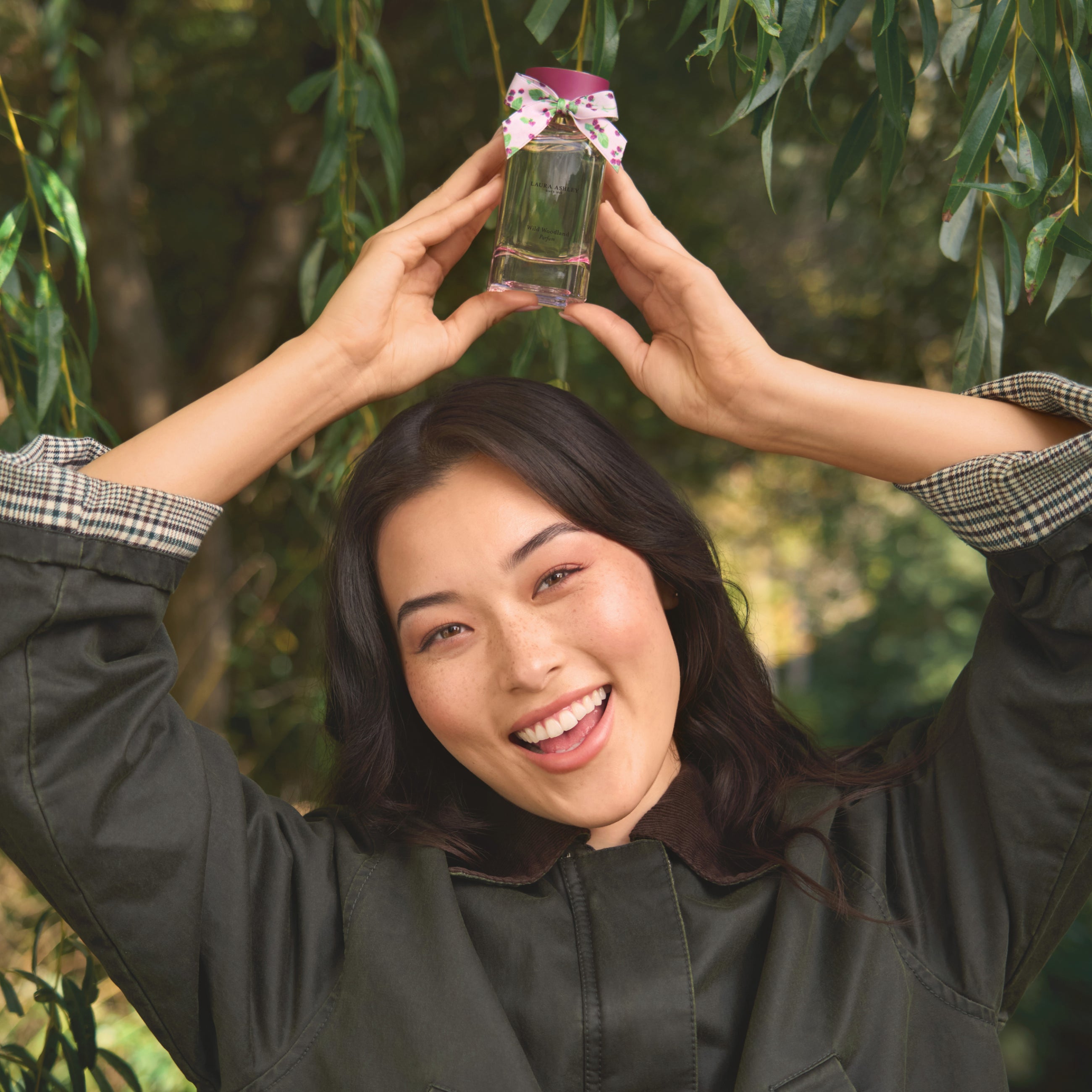 Person holding Wild Woodland against a green leafy background