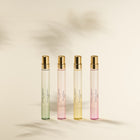 Set of four Laura Ashley gradient-coloured parfum bottles on a beige background