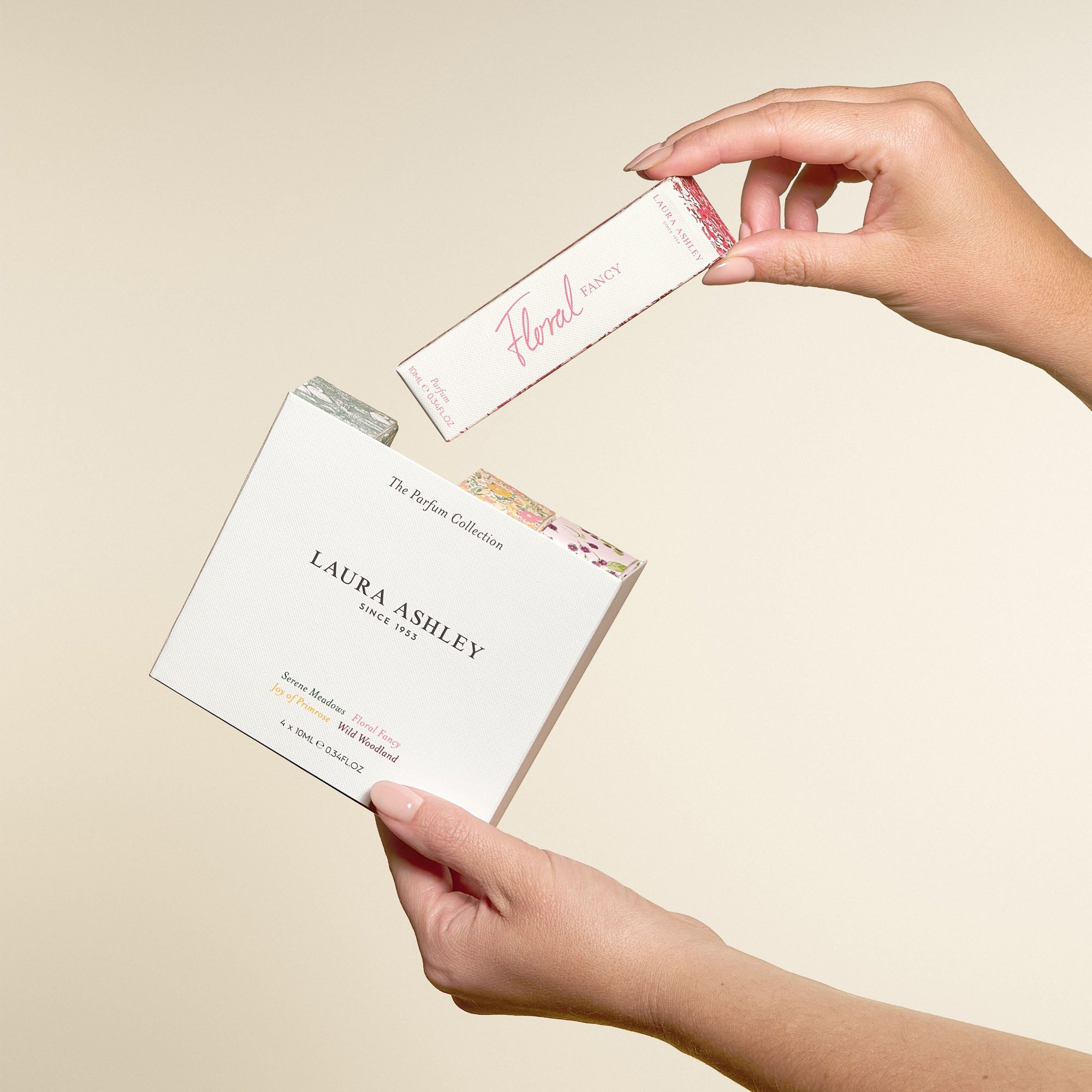 Laura Ashley perfume packaging with a hand holding it against a beige background